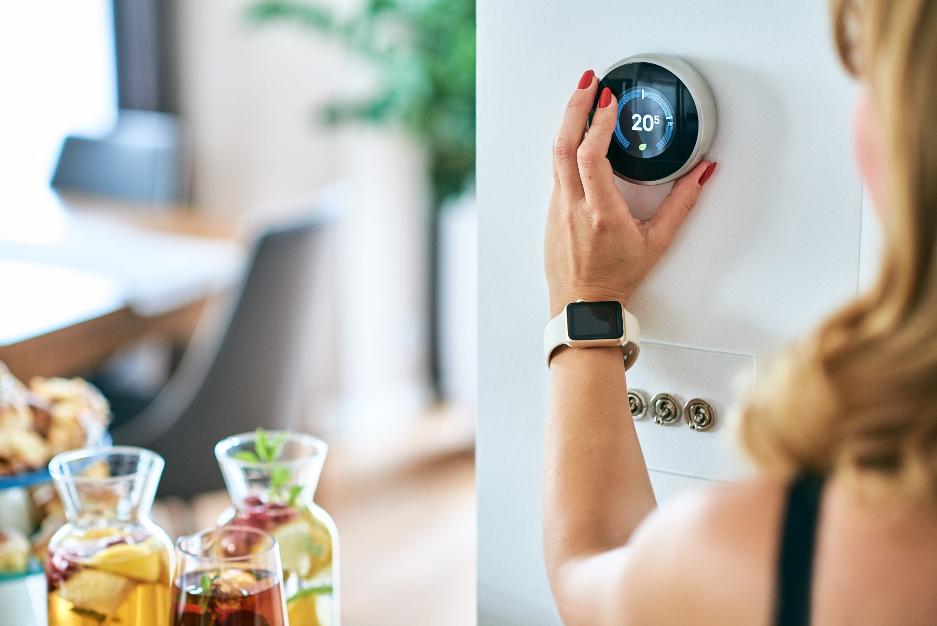 Woman using mart home automated thermostat 